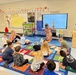 First-grade students at DoWEA Elliott Elementary participate in a phonics lesson on the classroom rug