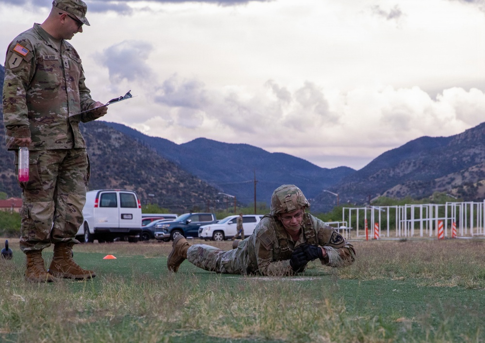U.S. Army soldier performs low crawl during physical fitness assessment at mountainous training installation