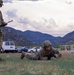 U.S. Army soldier performs low crawl during physical fitness assessment at mountainous training installation