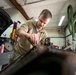 Vehicle maintenance specialist cleans engine gasket surfaces