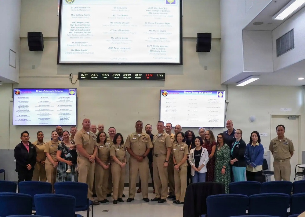 U.S. Navy personnel and civilian staff pose for group photo during Bravo Zulu and Special Recognition ceremony