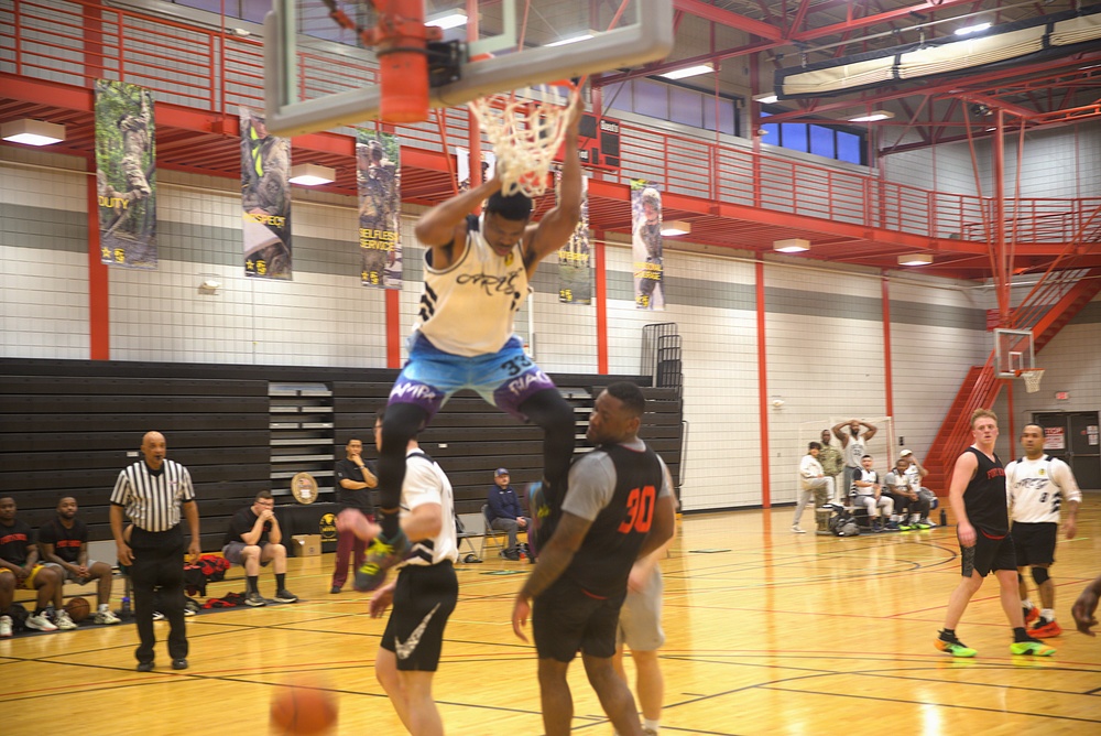 Player throws down emphatic dunk during intramural basketball game at military installation gymnasium