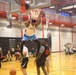 Player throws down emphatic dunk during intramural basketball game at military installation gymnasium