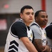 service members watch from the bench during an basketball game