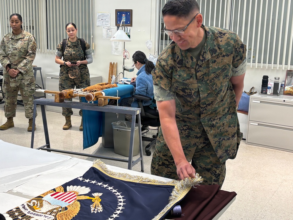 Sergeant Major of the Marine Corps Carlos Ruiz examines a nearly completed Presidential flag during a visit to Defense Logistics Agency Troop Support in Philadelphia on April 27.
