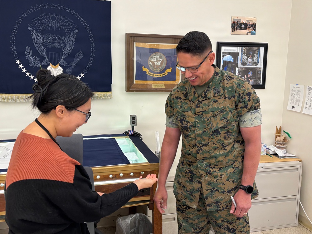 Sergeant Major of the Marine Corps Carlos Ruiz examines a nearly completed Presidential flag during a visit to Defense Logistics Agency Troop Support in Philadelphia on April 27.