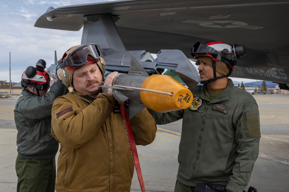U.S. service members unload ordnance from aircraft participating in exercise Red Flag-Alaska