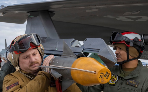 U.S. service members unload ordnance from aircraft participating in exercise Red Flag-Alaska