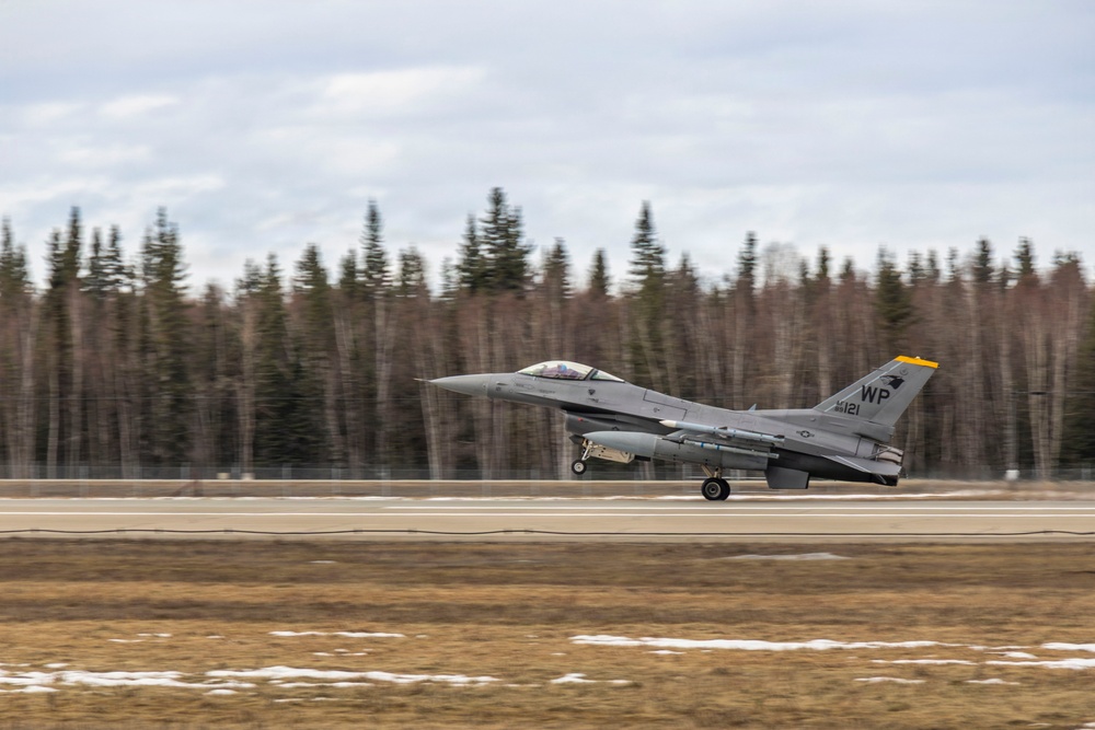 U.S. service members unload ordnance from aircraft participating in exercise Red Flag-Alaska