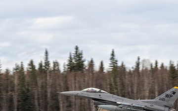 U.S. service members unload ordnance from aircraft participating in exercise Red Flag-Alaska
