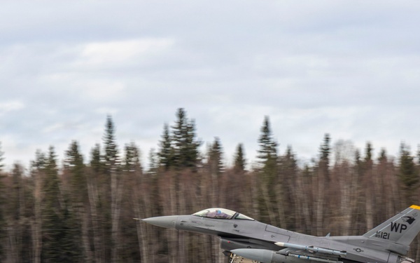 U.S. service members unload ordnance from aircraft participating in exercise Red Flag-Alaska