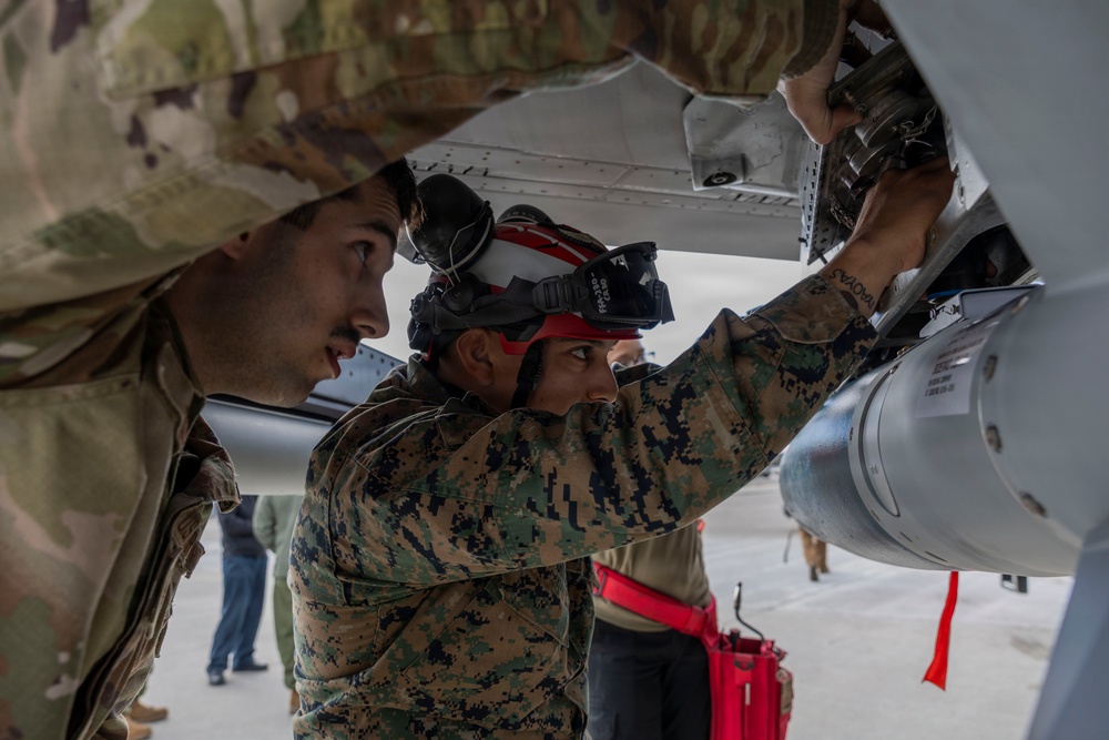 U.S. service members unload ordnance from aircraft participating in exercise Red Flag-Alaska