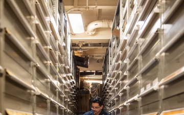 USS Mitscher (DDG 57) Sailor takes inventory in supply room