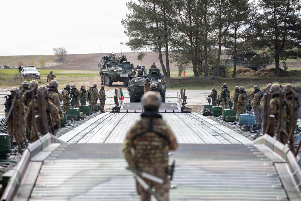 U.S. Soldiers from the 1st Squadron, 2d Cavalry Regiment, 809th Multi-Role Bridge Company, 15th Engineering Battalion, alongside Polish and Italian Armed Forces conduct a wet gap crossing