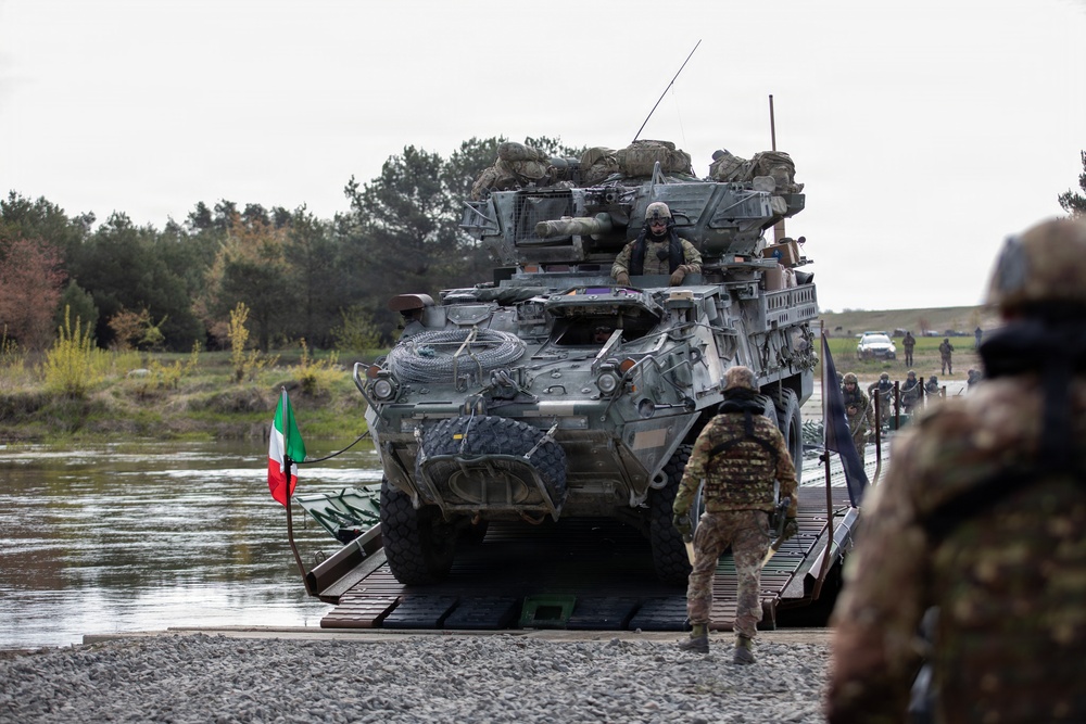 U.S. Soldiers from the 1st Squadron, 2d Cavalry Regiment, 809th Multi-Role Bridge Company, 15th Engineering Battalion, alongside Polish and Italian Armed Forces conduct a wet gap crossing