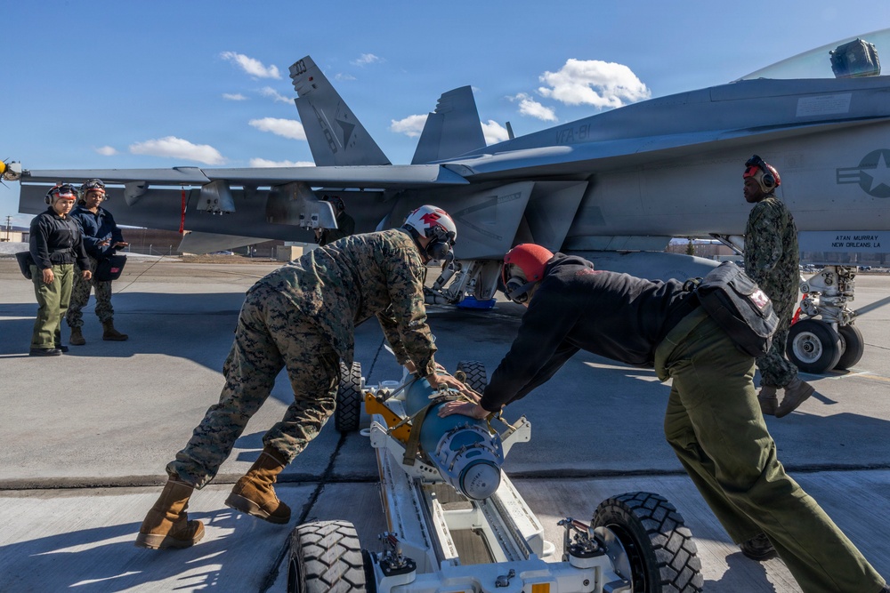 U.S. Marines and Sailors load ordnance on an F/A-18E Super Hornet