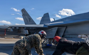 U.S. Marines and Sailors load ordnance on an F/A-18E Super Hornet