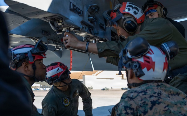 U.S. Marines and Sailors load ordnance on an F/A-18E Super Hornet