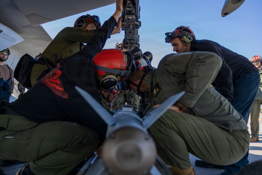 U.S. Marines and Sailors load ordnance on an F/A-18E Super Hornet