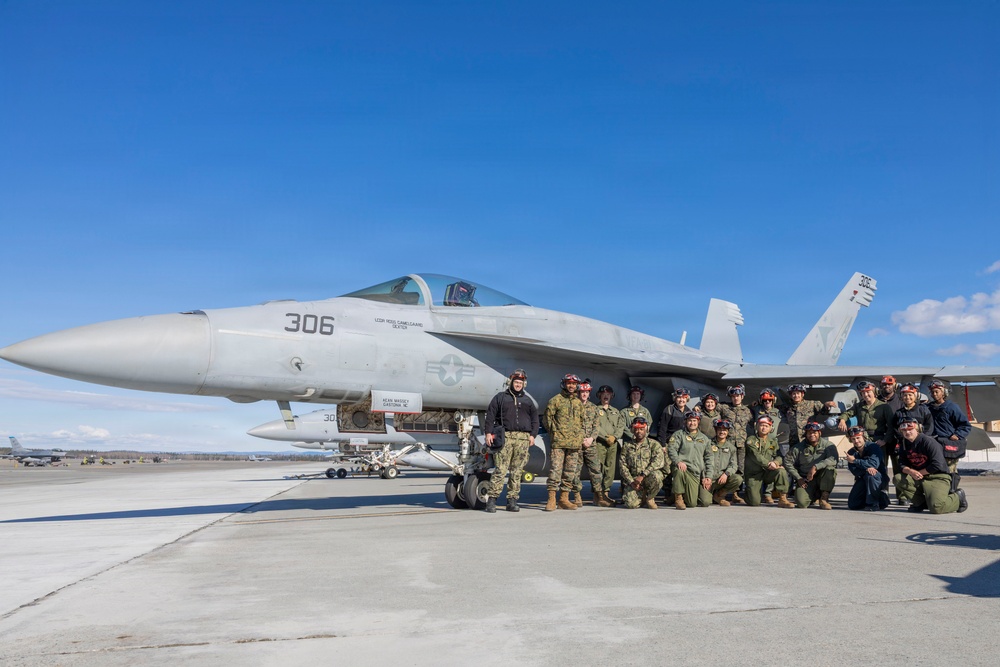 U.S. Marines and Sailors load ordnance on an F/A-18 Super Hornet