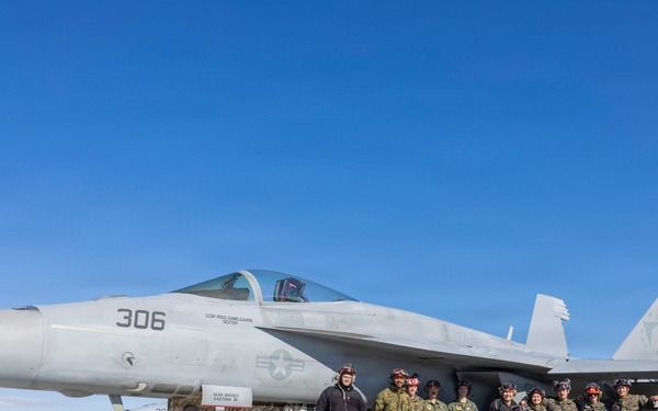 U.S. Marines and Sailors load ordnance on an F/A-18 Super Hornet