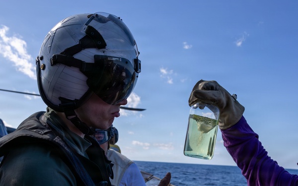 Sailors conduct fuel sample check prior to fueling a MH-60R Seahawk of HSM-46 on the USS Arleigh Burke