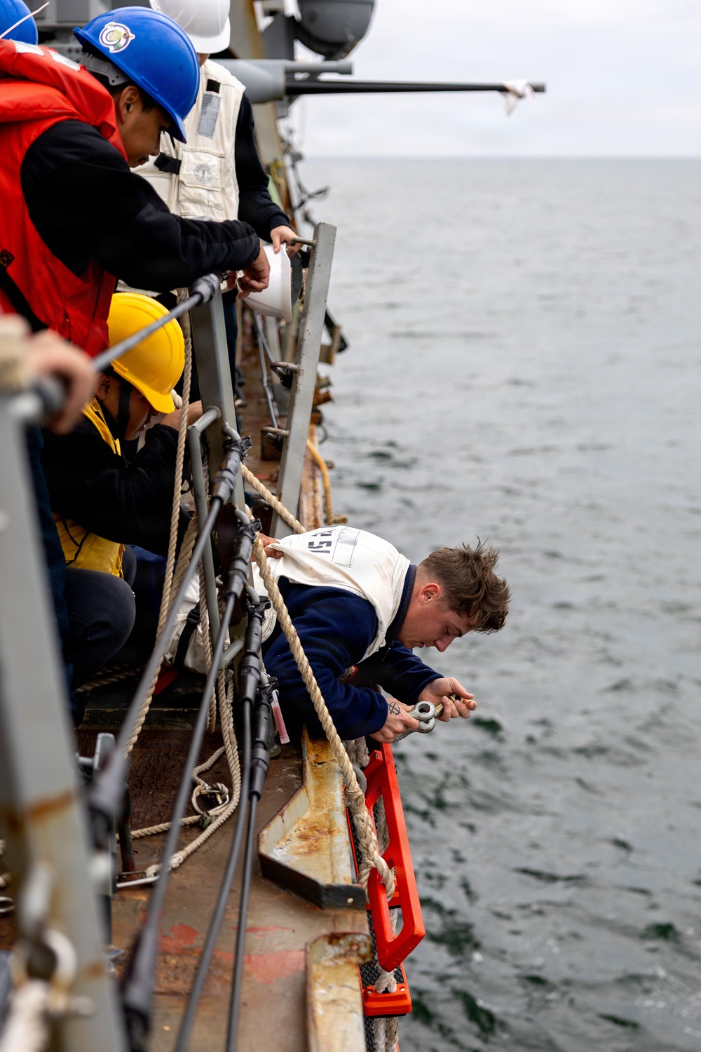 Sailor Detaches a Ladder During Small Boat Ops