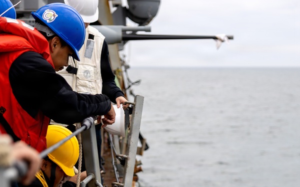 Sailor Detaches a Ladder During Small Boat Ops