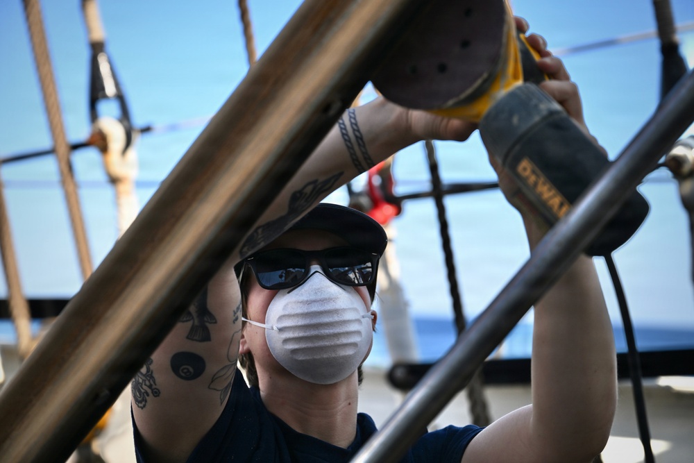 Coast Guard Cutter Eagle crew members conduct vessel upkeep