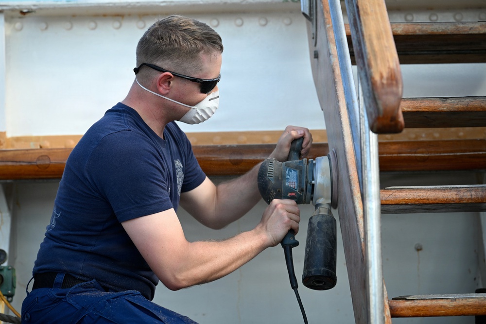 Coast Guard Cutter Eagle crew members conduct vessel upkeep
