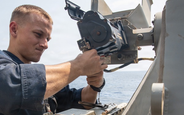 USS Mitscher (DDG 57) Sailor inspects 25mm gun