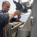 USS Mitscher (DDG 57) Sailor inspects 25mm gun
