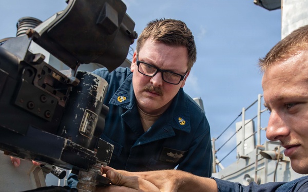 USS Mitscher (DDG 57) Sailors inspect 25mm machine gun