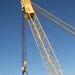 Large crane lifts dredge vessel during waterway construction or maintenance operation