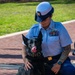 U.S. Coast Guard Service Member Poses with Military Working Dog During Ceremony