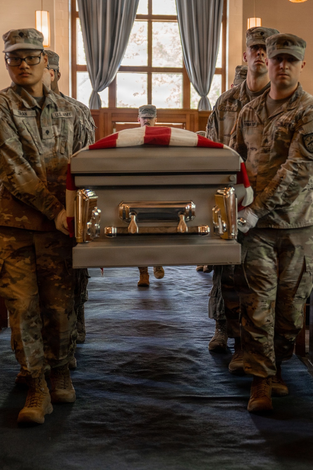 U.S. Army soldiers carry flag-draped casket during military funeral honors ceremony