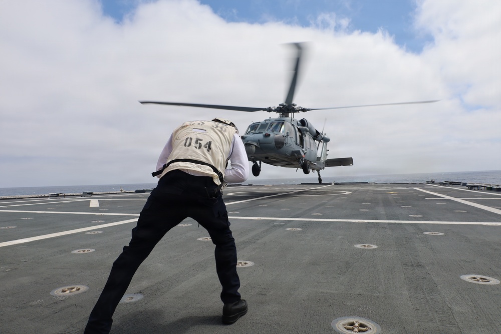 Aviation Boatswain's Mate Guides MH-60 Seahawk Helicopter Landing on Navy Ship Flight Deck