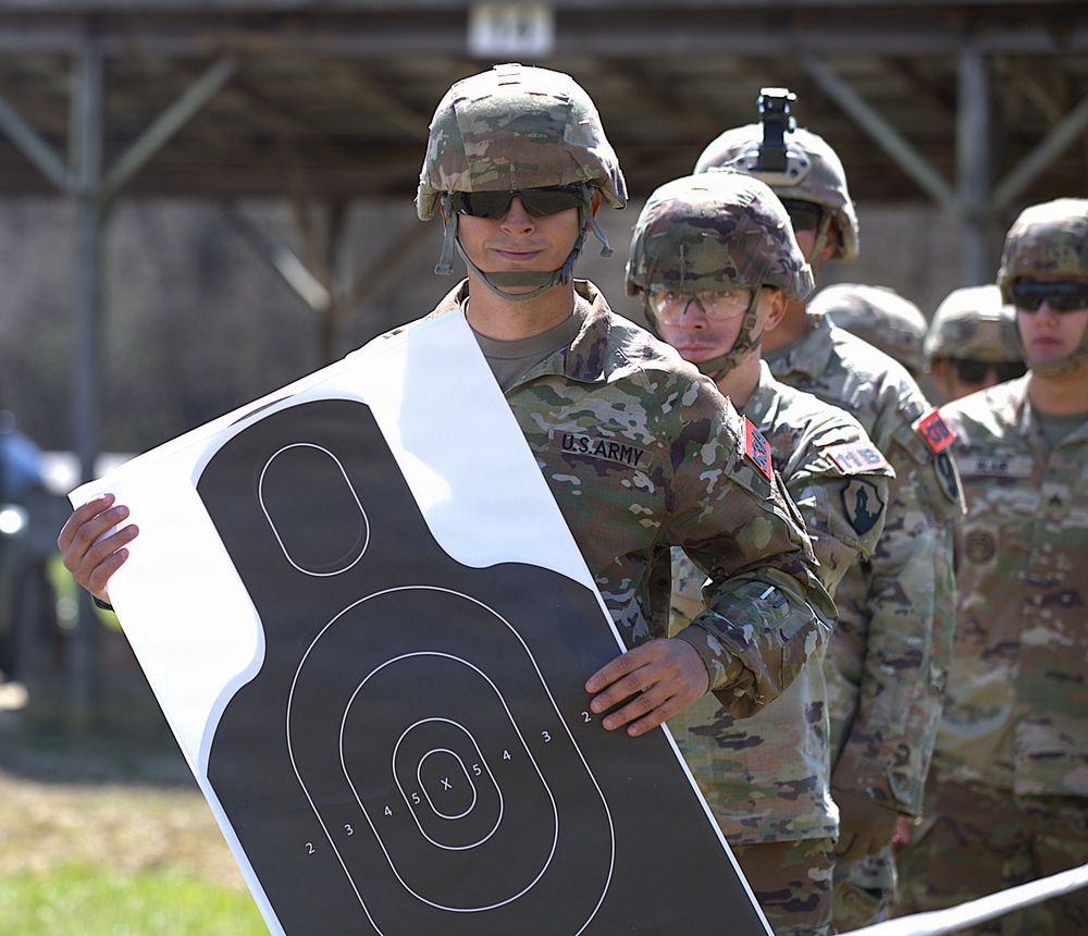 U.S. Army soldiers inspect paper targets during marksmanship qualification training at a firing range
