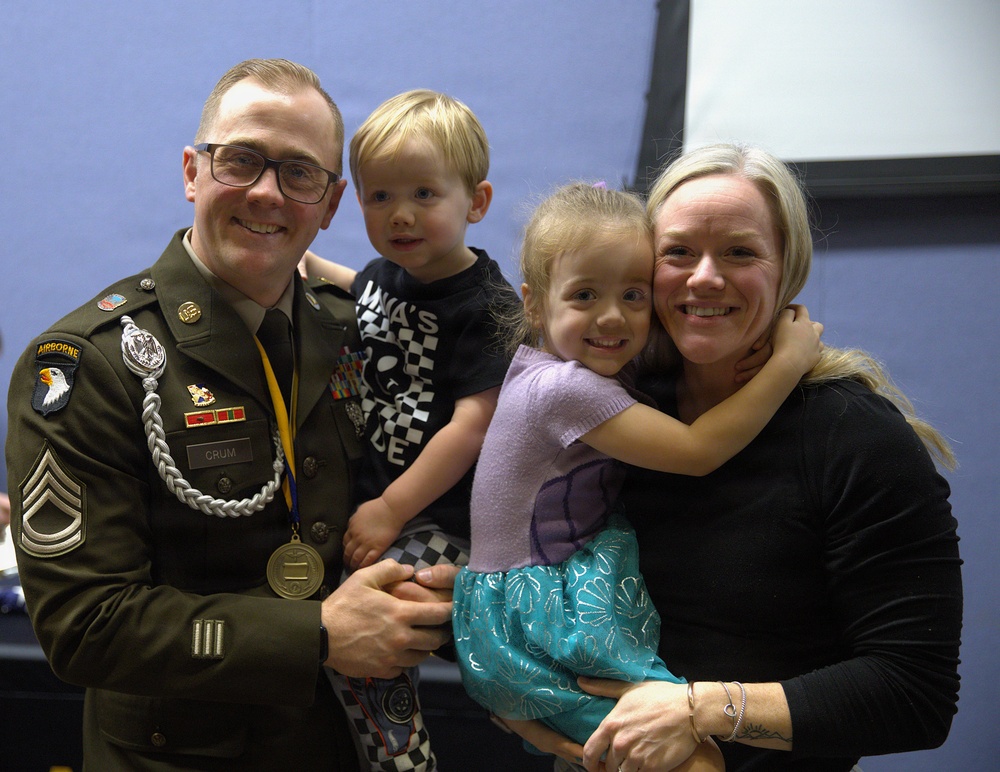 Army Staff Sergeant 1 Crum poses with family following awards ceremony
