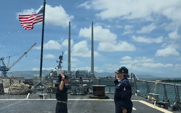 U.S. Navy sailors render honors during colors ceremony aboard warship at Pearl Harbor