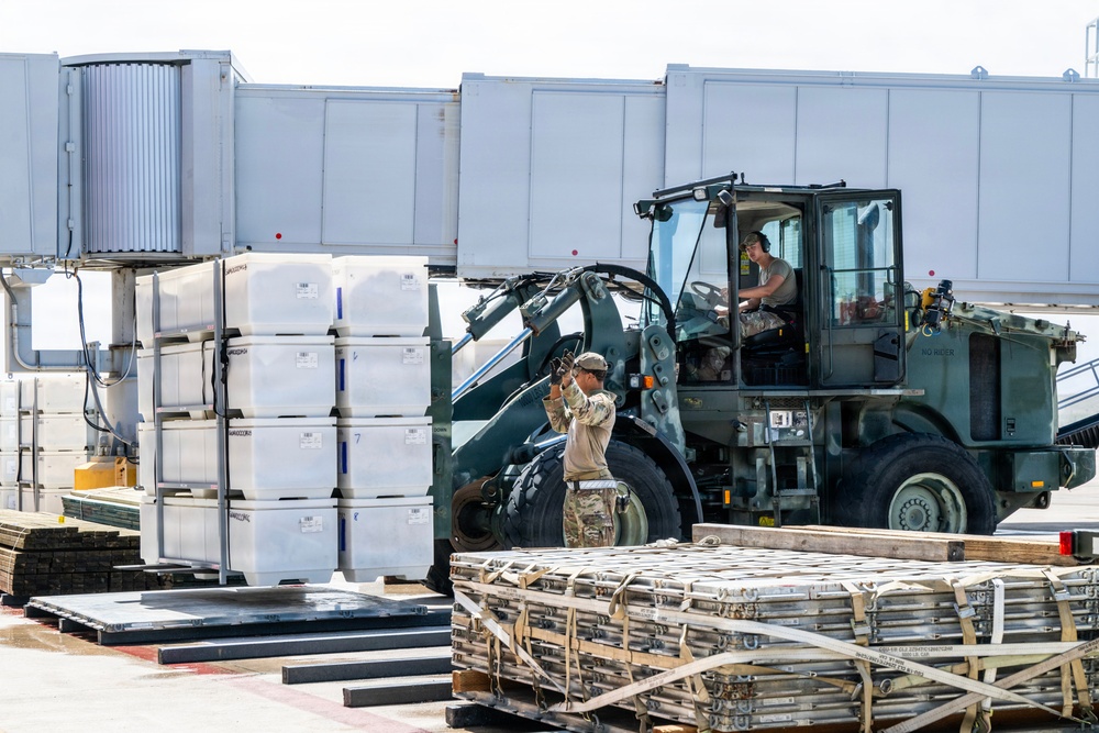 NMCB 1 Sailors and U.S. Airmen load wood cargo for roof restoration operations