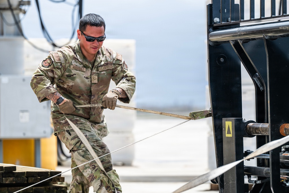 NMCB 1 Sailors and U.S. Airmen load wood cargo for roof restoration operations