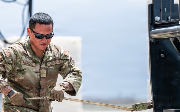 NMCB 1 Sailors and U.S. Airmen load wood cargo for roof restoration operations