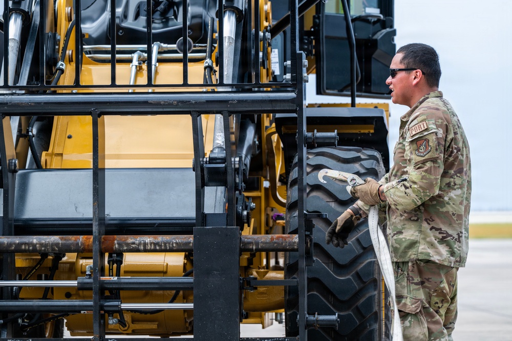 NMCB 1 Sailors and U.S. Airmen load wood cargo for roof restoration operations