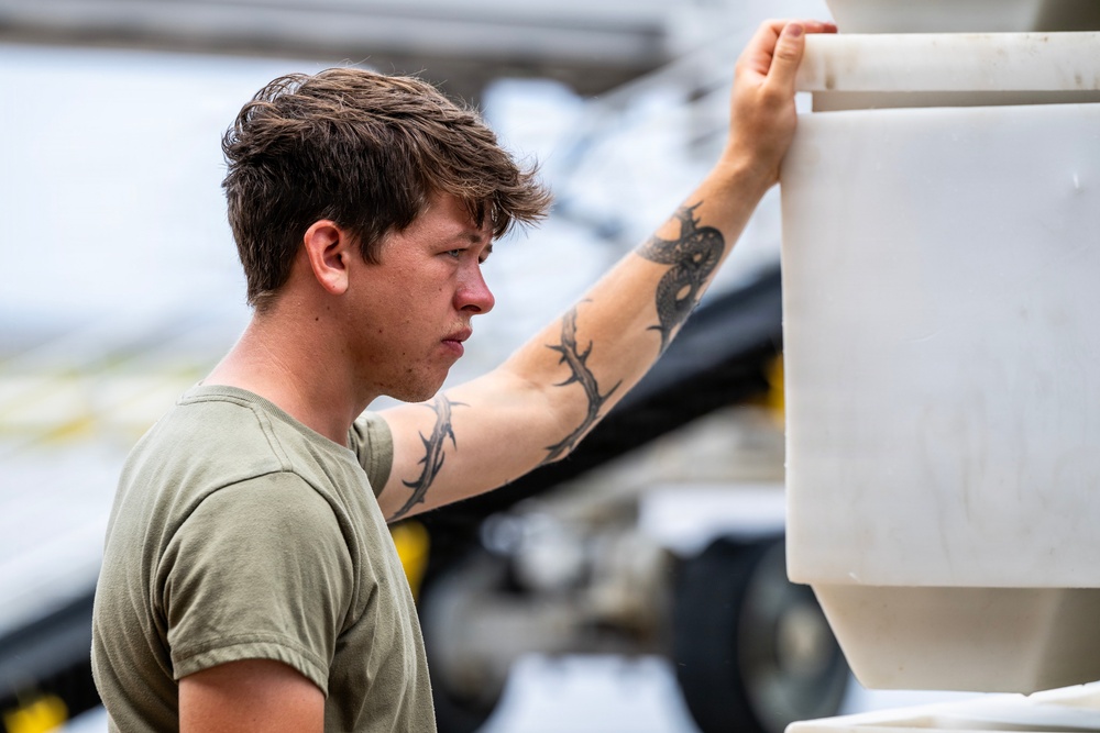 NMCB 1 Sailors and U.S. Airmen load wood cargo for roof restoration operations