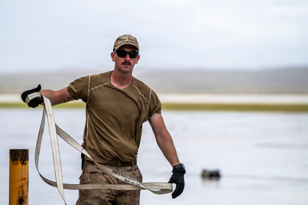 NMCB 1 Sailors and U.S. Airmen load wood cargo for roof restoration operations