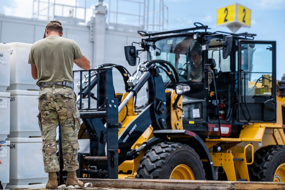 NMCB 1 Sailors and U.S. Airmen load wood cargo for roof restoration operations