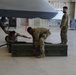 U.S. Air Force personnel conduct weapons loading operations on MQ-9 Reaper drone in hangar