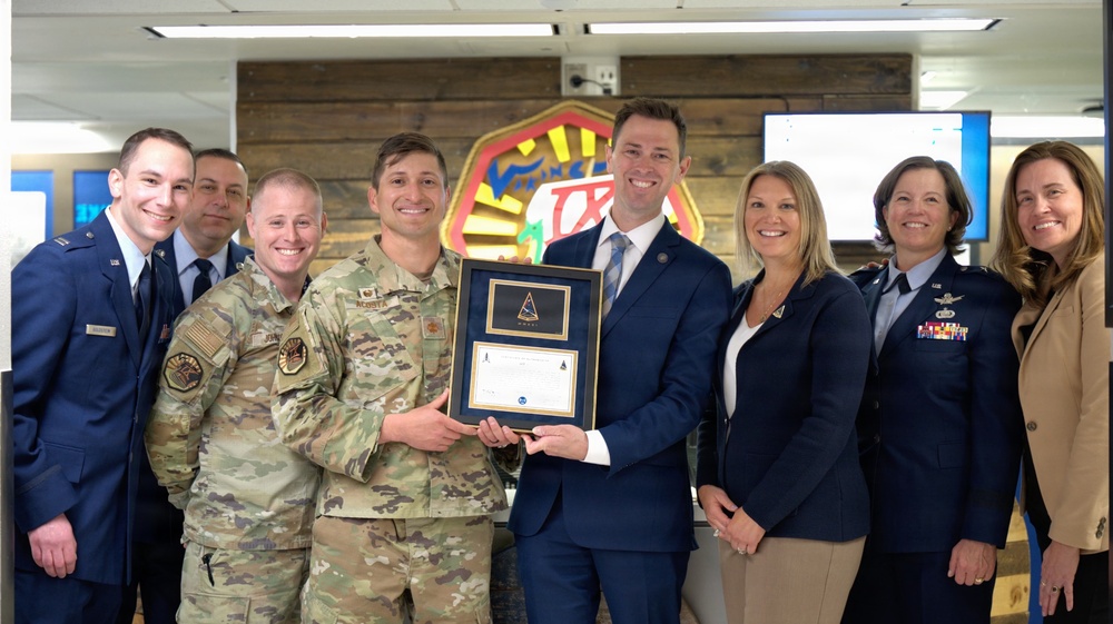 Space Systems Command presents Cadet Squadron 9 with a flag flown in space