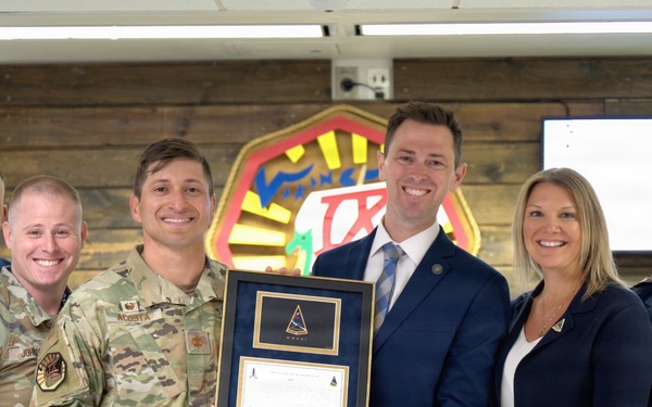 Space Systems Command presents Cadet Squadron 9 with a flag flown in space